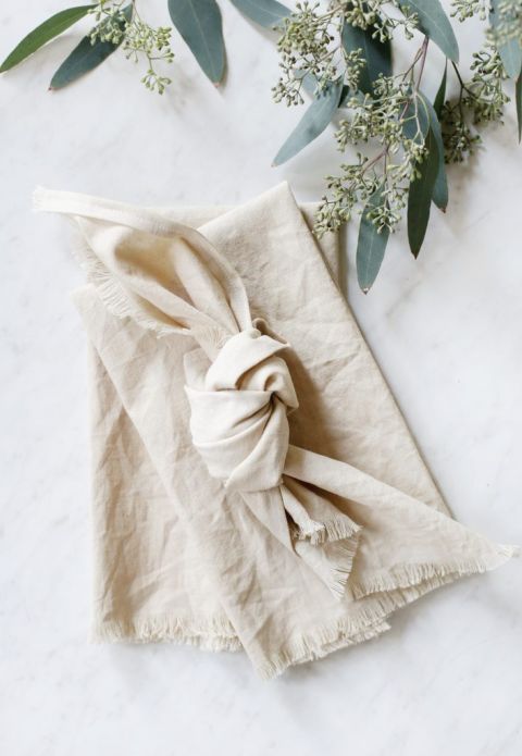 dyed linen napkins laid out on marble counter with eucalyptus