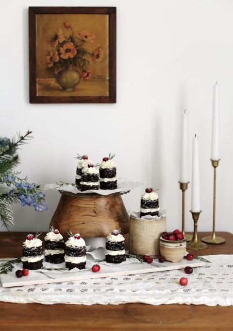 dessert display with cake stand surrounded by candles and bouquet