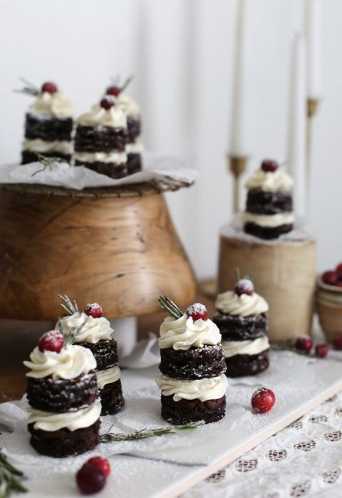 mini cakes on platter on a table with confection stand and candles in background