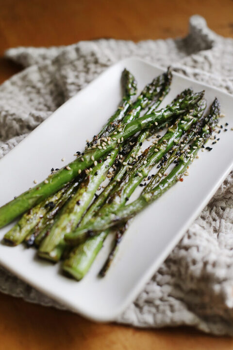 white platter of roasted asparagus on top of kitchen towel