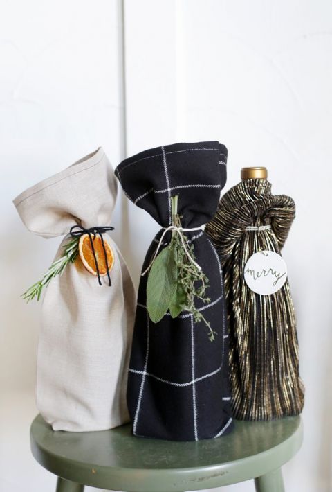 wine bottles in fabric bags with oranges and herbs