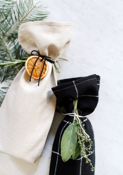 wine bottles in fabric bags with oranges and herbs