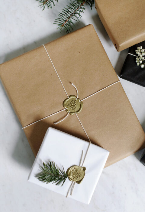 stacks of neutral wrapped presents, tied with twine and sealed with wax