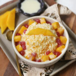 shaved mango bingsu in white bowl with fresh mango and boba on top