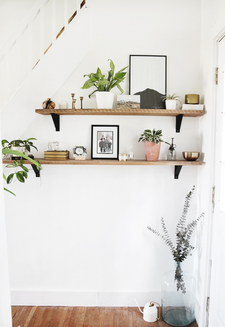 wood shelves with plants candles picture frames