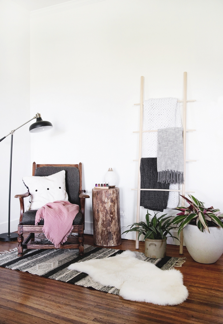 chair next to a blanket ladder and plants