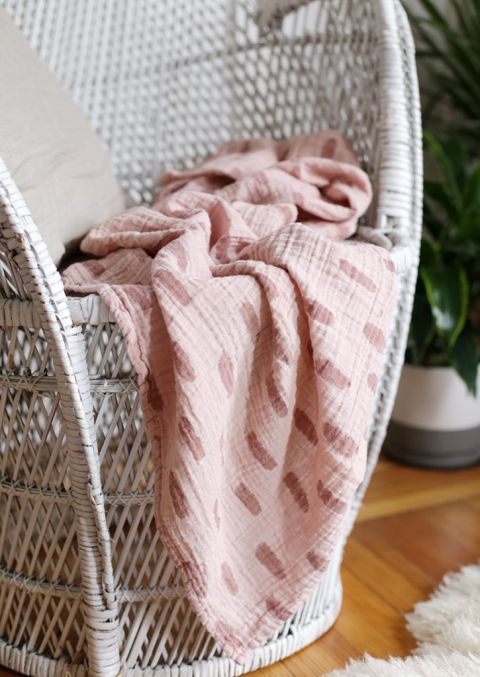 close up of pink muslin blanket on white chair
