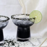 cocktail glass with black sugar rim and black cocktail