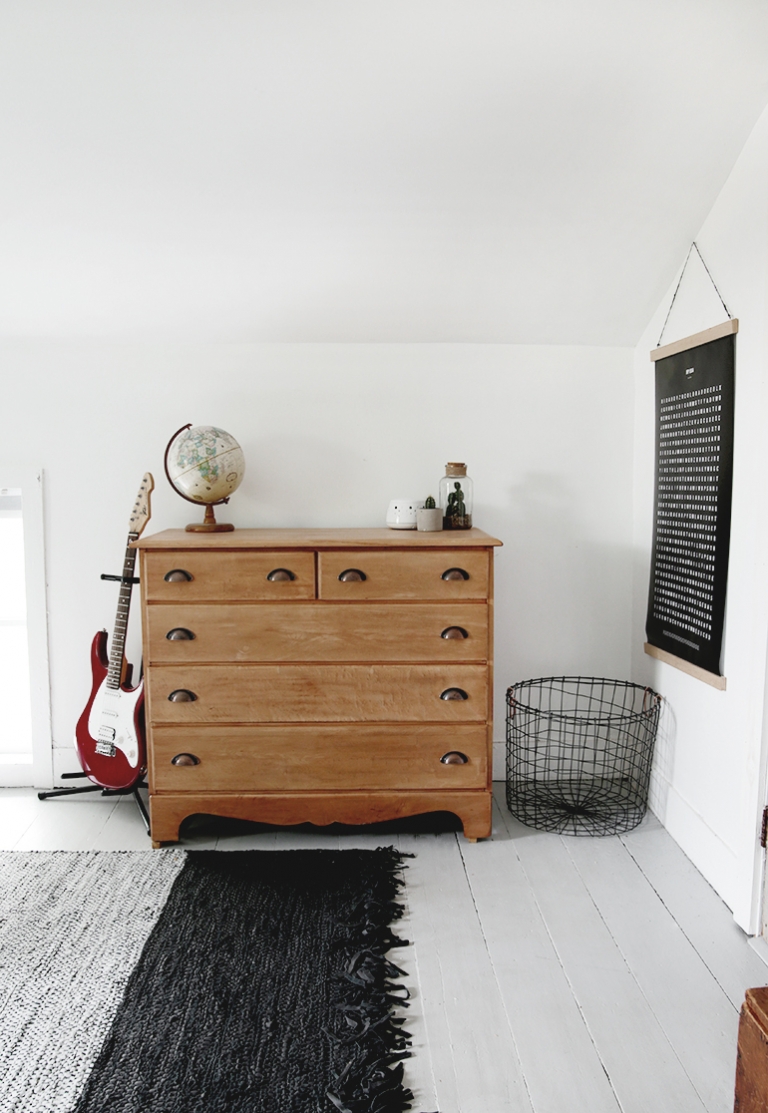 dresser with guitar and wire basket next to it