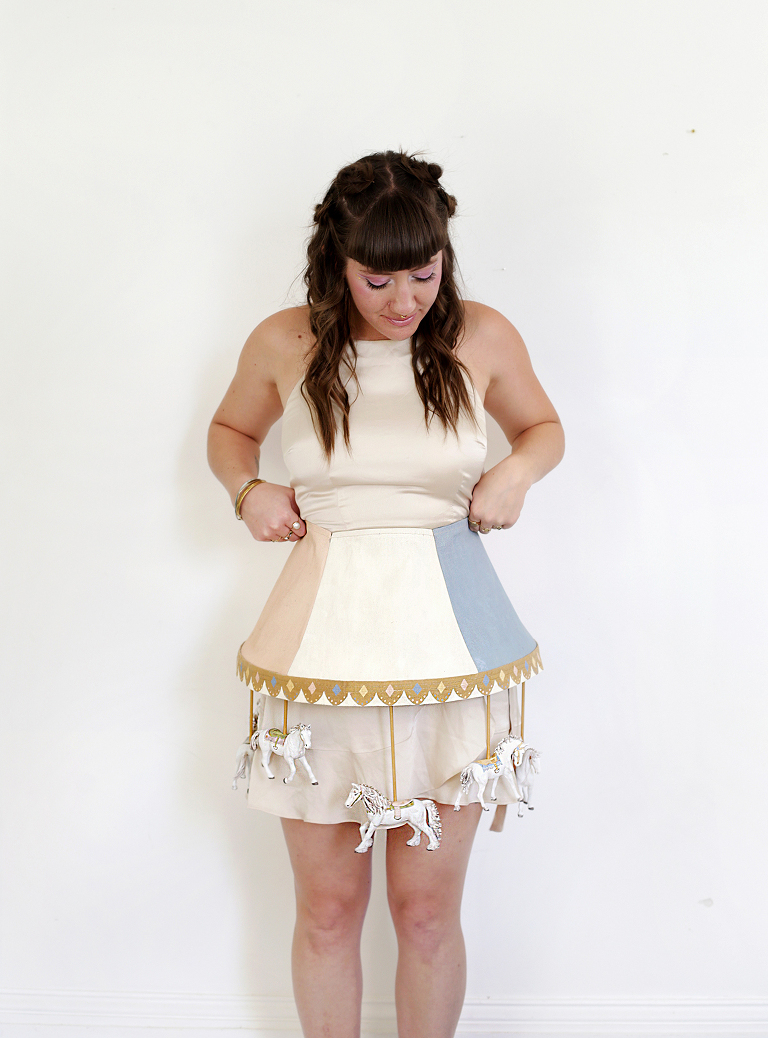 woman in front of white wall with vintage carousel costume