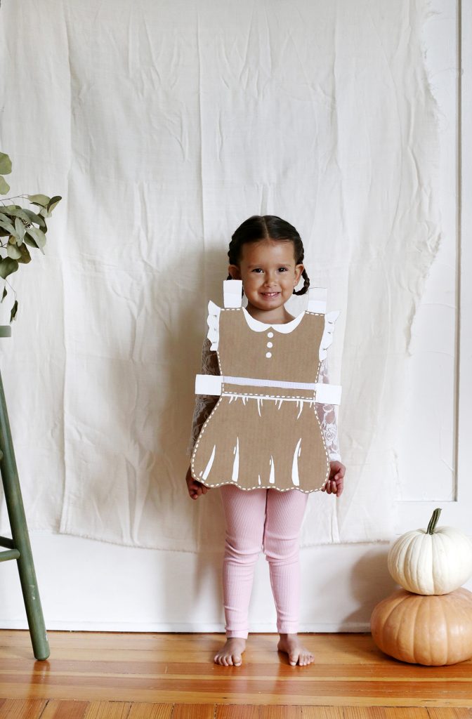 little girl in cardboard paper doll costume