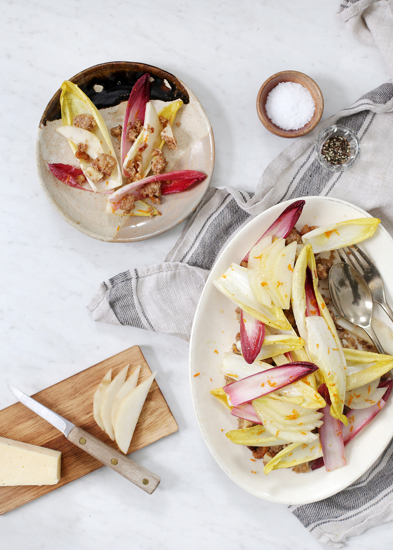 overhead shot of endive salad platter with small ceramic plate to the side with small serving of salad