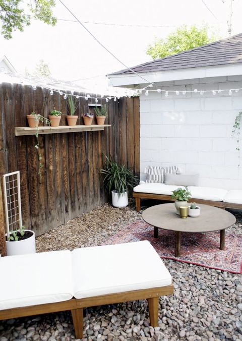 backyard living space with plants and patio chairs