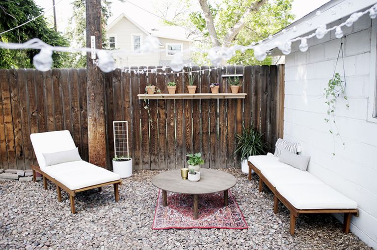 backyard living space with plants and patio chairs