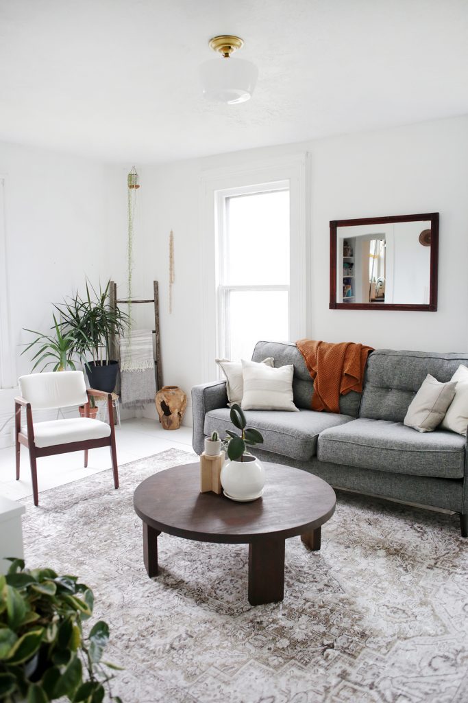 white living room with grey cough and circular coffee table