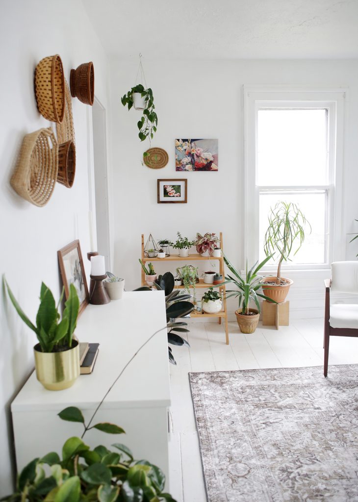 white room with plants and art and basket decor