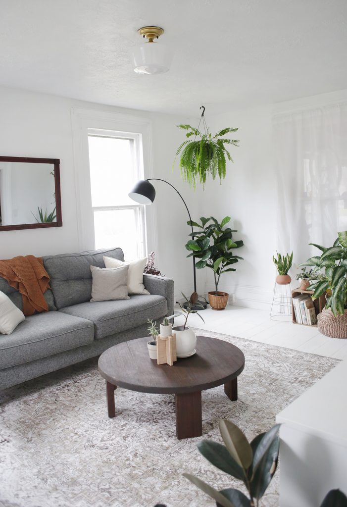 white living room with grey cough and circular coffee table
