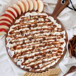 round wearing workbench with surf cheese and caramel spread on top surrounded by snacks