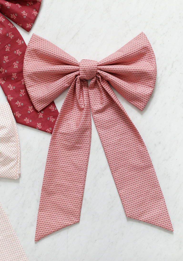 Large pink fabric bow laid on white marble