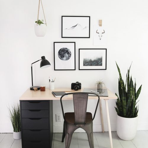 desk with black drawers and framed artwork above