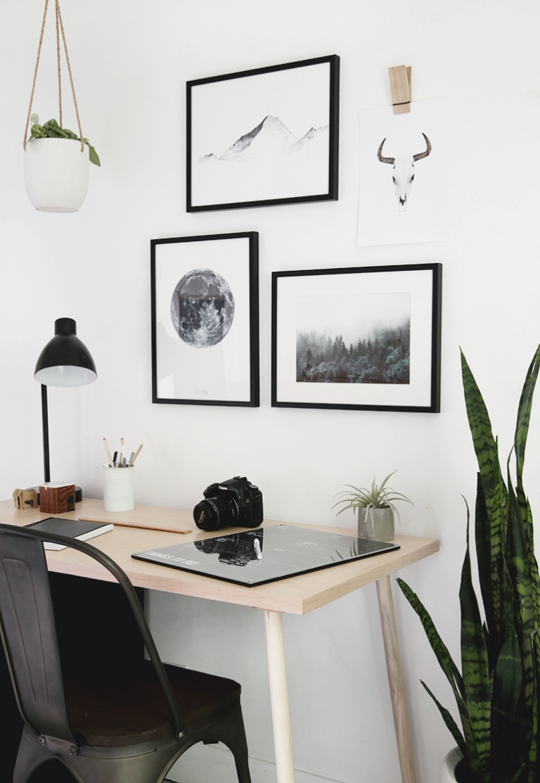 wood desk with framed prints above
