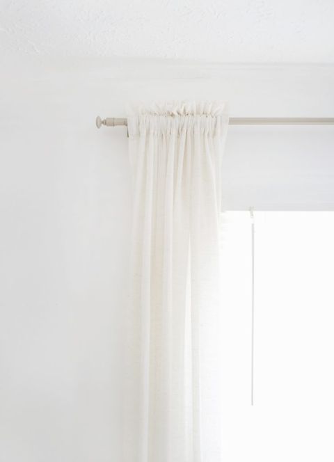 close up of curtain rod and curtain against white wall
