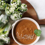 summer rolls on cutting board next to sauce