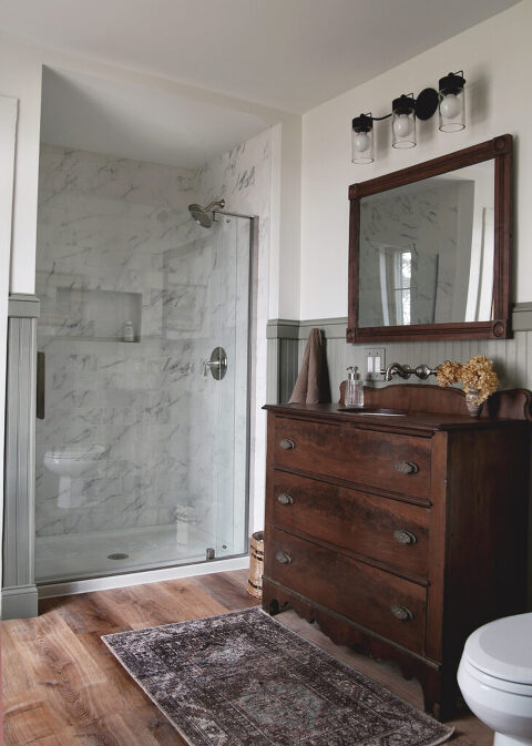 bathroom with wood bathroom vanity and glass door tiled shower