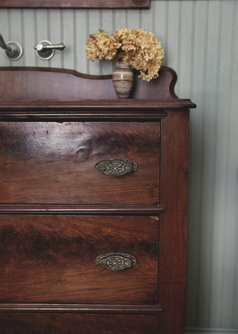 close up of dresser bathroom vanity with flowers on top