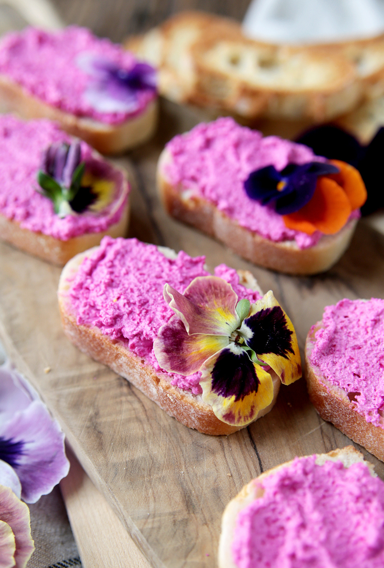 crostini topped with beet whipped feta and edible flowers