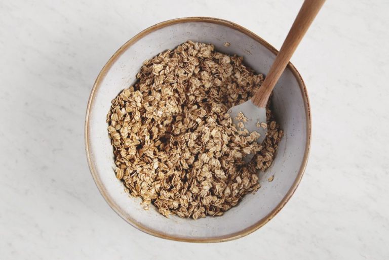 mixing bowl with rolled oats and spatula in it