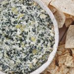 round baking dish with spinach dip and bread and chips