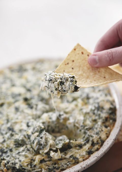 tortilla chip with spinach and artichoke dip on it