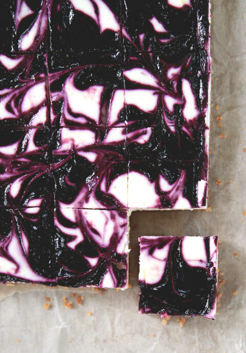 black raspberry cheesecake bars with one square cut out of corner