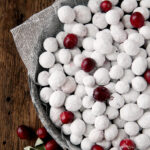 close up shot of metal pie plate filled with powdered sugar cranberries and regular cranberries