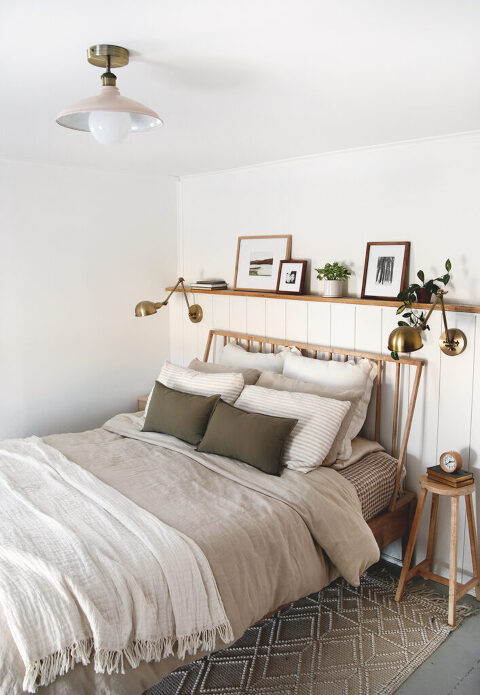 bedroom with white walls, vertical wood boards and a beige and brass ceiling light