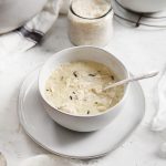 rice chicken soup in a white bowl with spoon in bowl