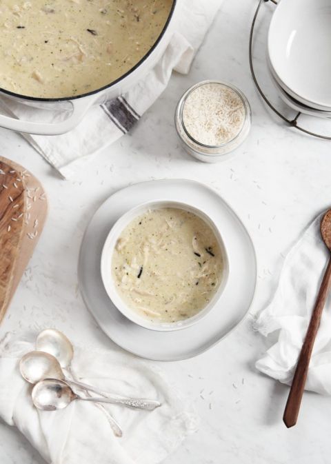 creamy soup in a white bowl next to pot of soup