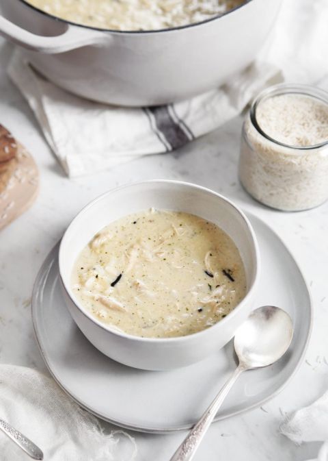 white bowl filled with creamy chicken soup on white plate with spoon