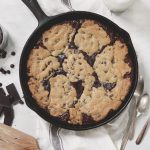 skillet brookie on towel with spatula next to it