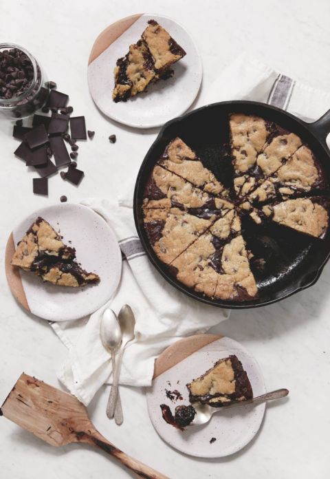 skillet cookie sliced next to plates with pieces of cookies on them