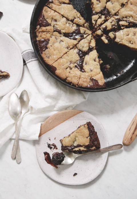 skillet brookie with slice of cookie on plate next to it