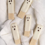 white chocolate dipped ghost wafer cookies on white cloth