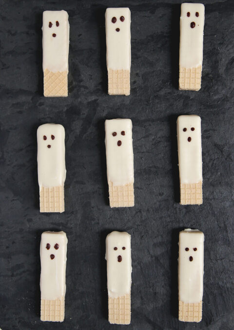 white chocolate dipped ghost wafer cookies on slate stone