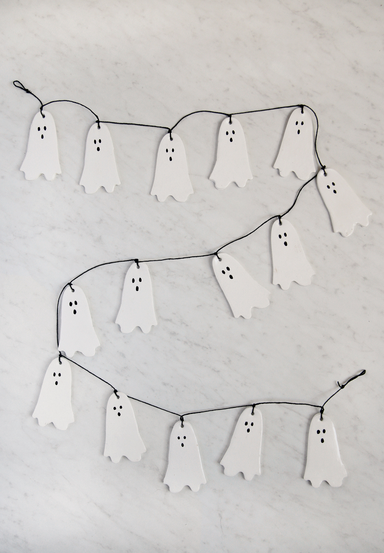 white ghost clay garland with black string laying on marble backdrip