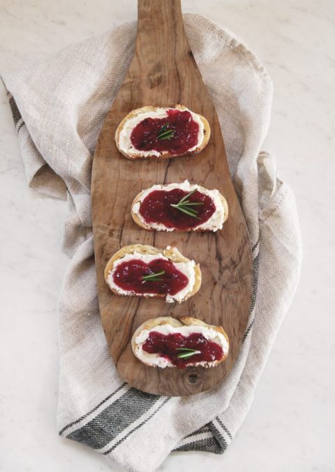 4 crostini appetizer with cranberry sauce & feta on cutting board