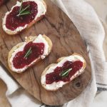 3 cranberry whipped feta crostini on wearing board