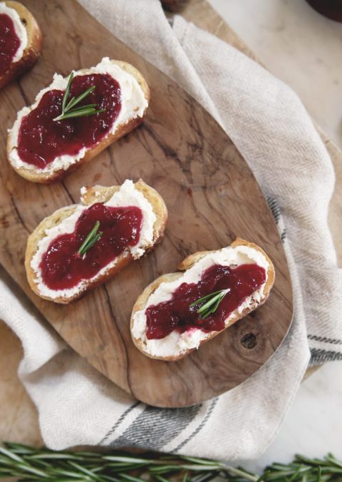 3 cranberry whipped feta crostini on wearing board