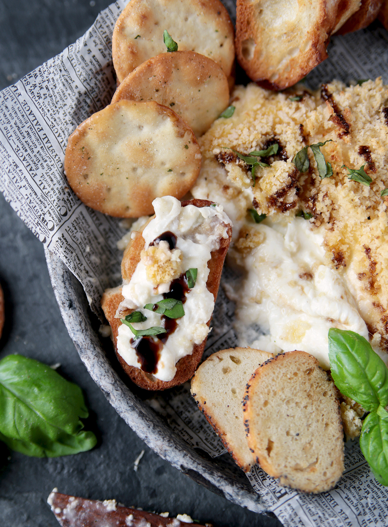 crostini with burrata cheese on it with balsamic glaze and basil on top