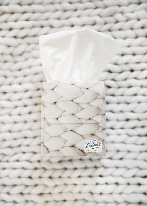 white tisssue box sitting on a white knit blanket
